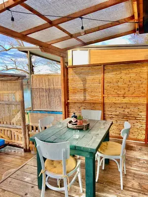 a dining room with a green table and chairs at Barbana Cottage , Ada Bojana in Ulcinj