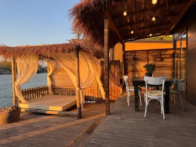 a porch with a bed and a table and chairs at Barbana Cottage , Ada Bojana in Ulcinj