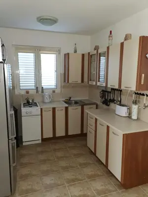 a kitchen with white appliances and wooden cabinets at Schmidt in Lastva