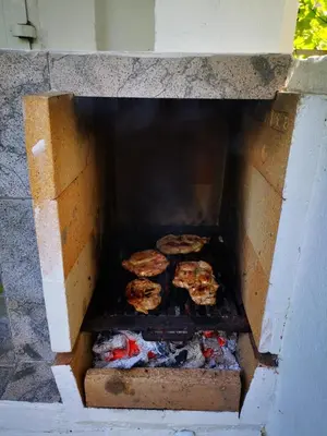 a brick oven with food cooking on a grill at Schmidt in Lastva