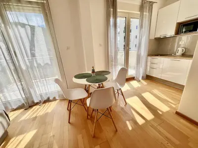 a kitchen with a table and chairs in a room at Palma in Budva