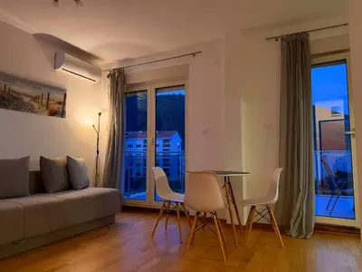 a living room with a couch and a table and chairs at Palma in Budva