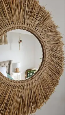a large woven rattan mirror hanging on a wall at Monte View Apartments in Ulcinj