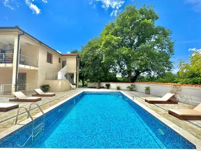 a swimming pool in front of a house at STARS RESIDENCE in Petrovac na Moru