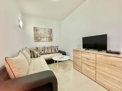 a living room with a couch and a flat screen tv at STARS RESIDENCE in Petrovac na Moru
