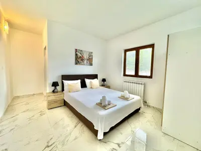 a bedroom with a large white bed with two trays on it at STARS RESIDENCE in Petrovac na Moru