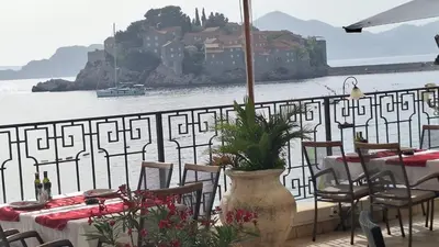 a table and chairs with a view of the water at Luxury Apartments Montesan in Sveti Stefan