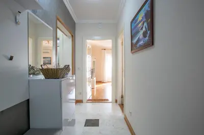 a hallway with a white kitchen with a painting on the wall at Luxury Apartments Montesan in Sveti Stefan
