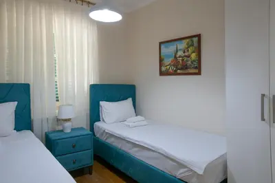 a bedroom with two beds and a picture on the wall at Luxury Apartments Montesan in Sveti Stefan