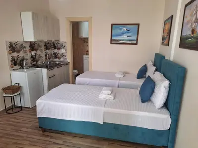 a small bedroom with two beds and a kitchen at Luxury Apartments Montesan in Sveti Stefan