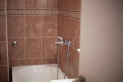 a bathroom with a shower with a white tub at City View Studio in Podgorica