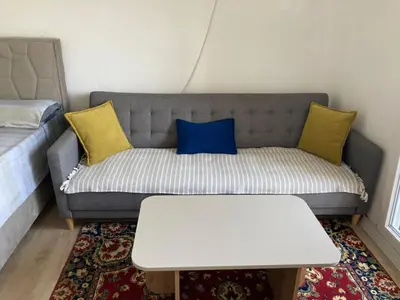 a couch with yellow and blue pillows in a living room at City View Studio in Podgorica