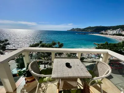 a table and chairs on a balcony overlooking the ocean at Apartments AriaSana-5m from the beach in Dobra Voda