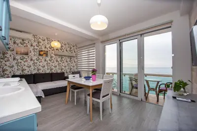 a living room with a couch and a table with a view at Apartments AriaSana-5m from the beach in Dobra Voda