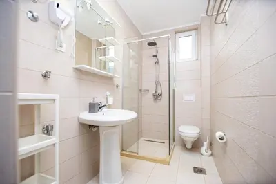a bathroom with a sink and a shower and a toilet at Apartments AriaSana-5m from the beach in Dobra Voda