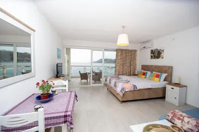 a bedroom with a bed and a view of the ocean at Apartments AriaSana-5m from the beach in Dobra Voda