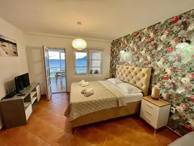 a bedroom with a bed with a flowery wall at Apartments AriaSana-5m from the beach in Dobra Voda