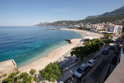 a view of a beach with cars parked on it at Apartments AriaSana-5m from the beach in Dobra Voda