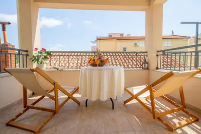 a table and two chairs on a balcony with a view at Guest House Medin in Petrovac na Moru