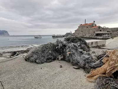 a pile of nets on a beach next to the water at Guest House Medin in Petrovac na Moru