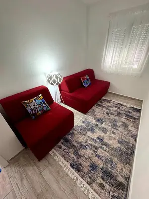 a living room with two red couches and a rug at D&D in Bar