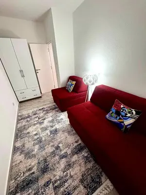 a living room with a red couch and a lamp at D&D in Bar