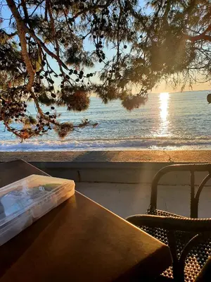 a wooden table with a view of the ocean at D&D in Bar