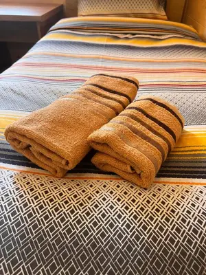 two towels are sitting on a bed at Cozy bungallows in Podgorica