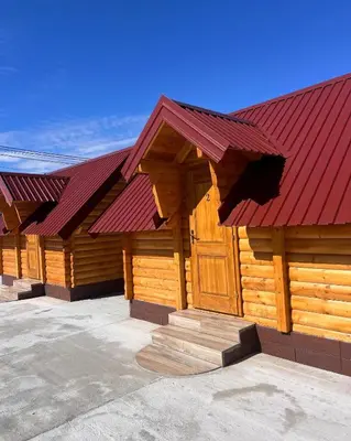 a large wooden building with a red roof at Cozy bungallows in Podgorica