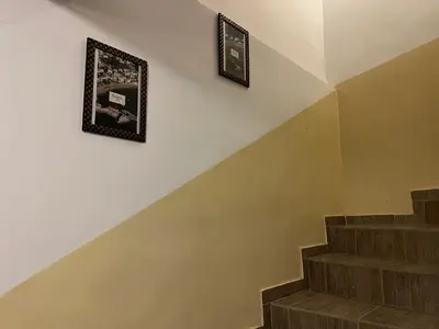 two pictures hanging on a wall above a staircase at Apartments Teodora Obala in Petrovac na Moru