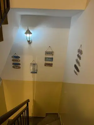 a staircase with a light on a wall with signs on it at Apartments Teodora Obala in Petrovac na Moru