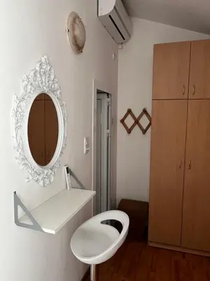 a bathroom with a white toilet and a mirror at Apartments Teodora Obala in Petrovac na Moru