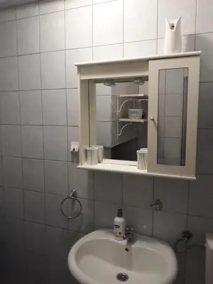 a white bathroom with a sink and a mirror at Apartments Teodora Obala in Petrovac na Moru