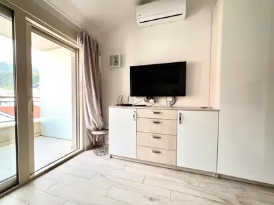 a living room with a television on a dresser at Apartmani More in Budva