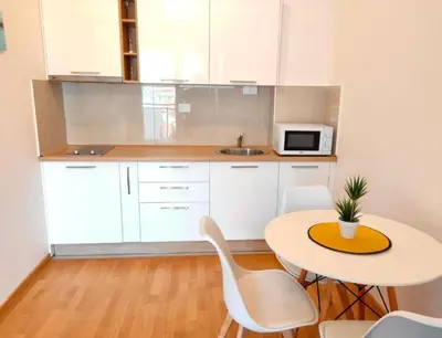 a kitchen with a table and chairs and a microwave at Apartmani More in Budva