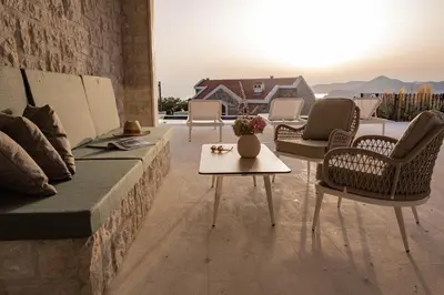 a patio with chairs and a couch and a table at Belsize Villas in Budva