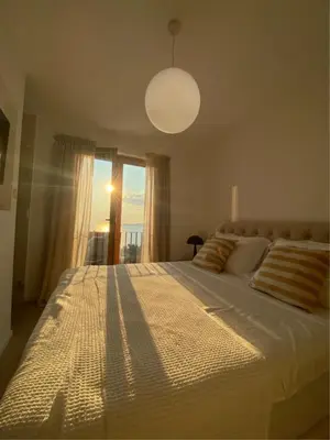 a bedroom with a large bed with a large window at Belsize Villas in Budva