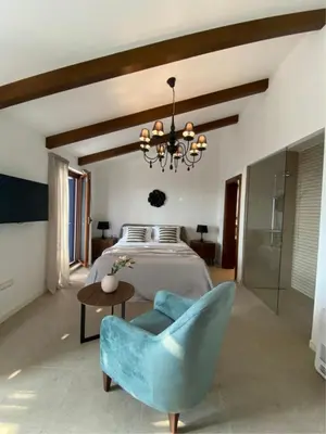 a bedroom with a bed and a blue chair at Belsize Villas in Budva