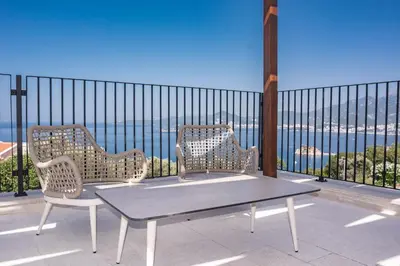two chairs and a table on a balcony with a view at Belsize Villas in Budva