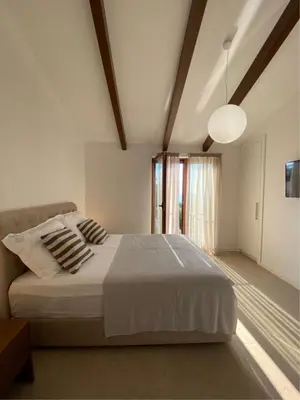 a bedroom with a large white bed and a window at Belsize Villas in Budva