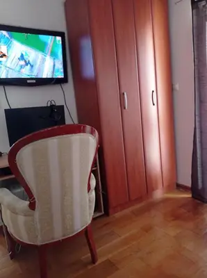 a living room with a chair and a tv at Apartman Fontana in Budva