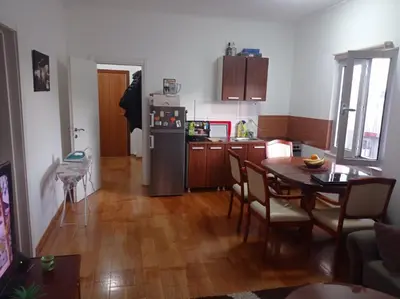 a kitchen and dining room with a table and a refrigerator at Apartman Fontana in Budva