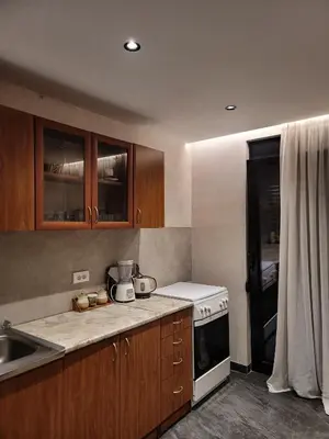a kitchen with wooden cabinets and a white stove top oven at Casa L in Ulcinj