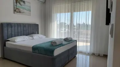 a bedroom with a bed and a large window at D&M Studio Apartments in Bar