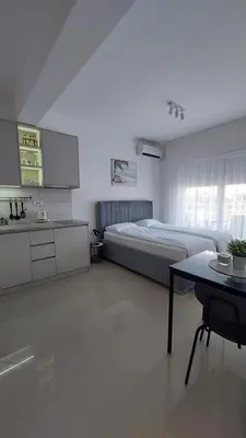 a bedroom with a bed and a table and a kitchen at D&M Studio Apartments in Bar