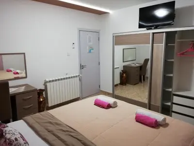 a bedroom with a bed with two pink pillows on it at Apartments Familia in Budva