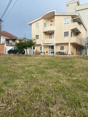 a large building in front of a grass field at Starlight Apartments in Ulcinj