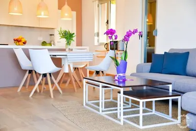 a living room with a couch and a table with flowers on it at A1 2 beds 2 baths Lux Condo Pool Sea Views in Tivat