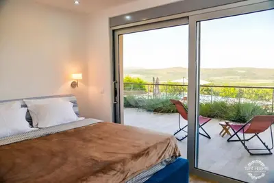 a bedroom with a bed and a sliding glass door at A1 2 beds 2 baths Lux Condo Pool Sea Views in Tivat