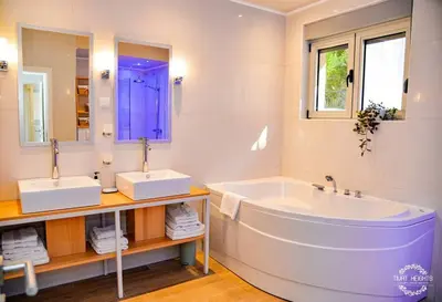 a white bathroom with a tub and two sinks at A1 2 beds 2 baths Lux Condo Pool Sea Views in Tivat